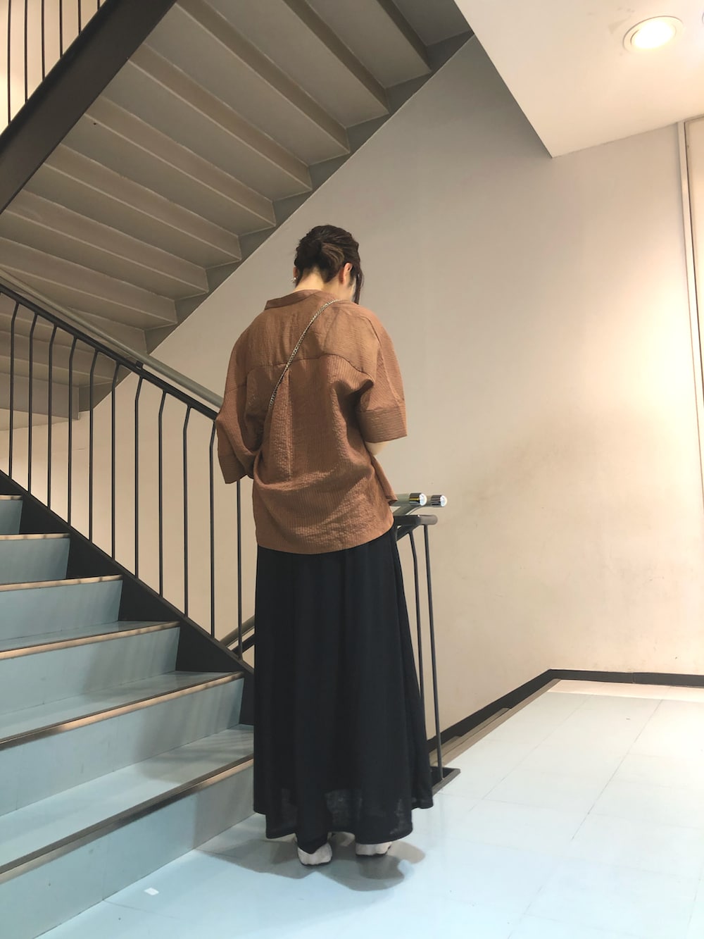 ブラウン系のシャツ/ブラウス、ブラック系のワンピース、イエロー系のハンドバッグを着用したレディースの春コーディネートの2枚目の写真