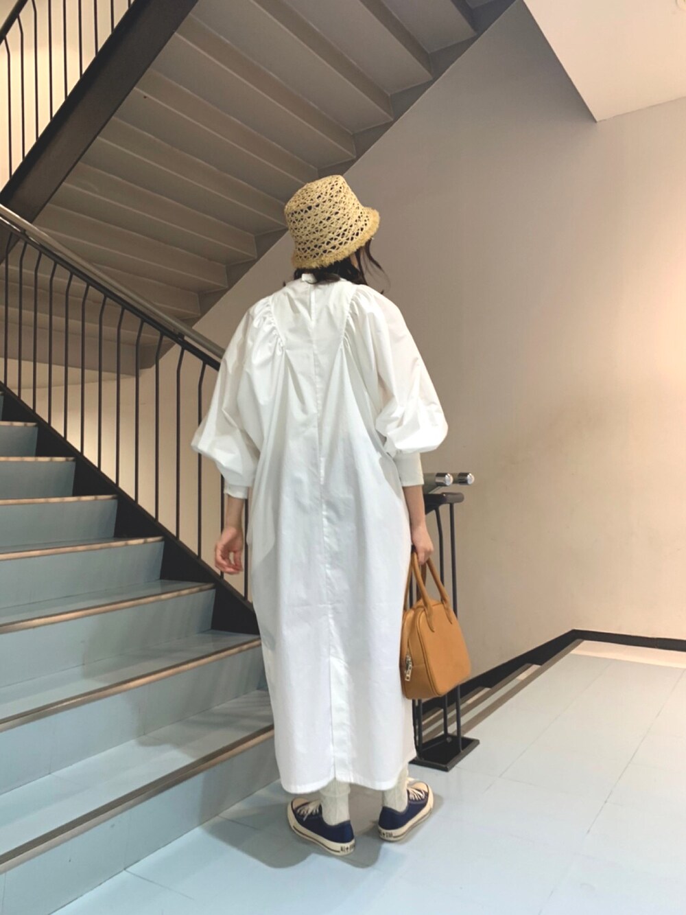 ホワイト系のワンピース、イエロー系のボストンバッグ、ベージュ系のハットを着用したレディースの春コーディネートの2枚目の写真