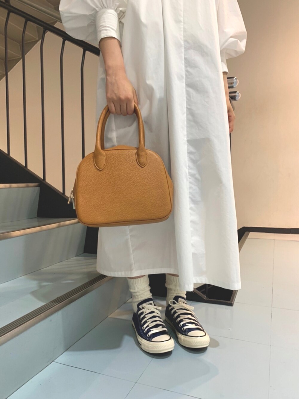 ホワイト系のワンピース、イエロー系のボストンバッグ、ベージュ系のハットを着用したレディースの春コーディネートの4枚目の写真