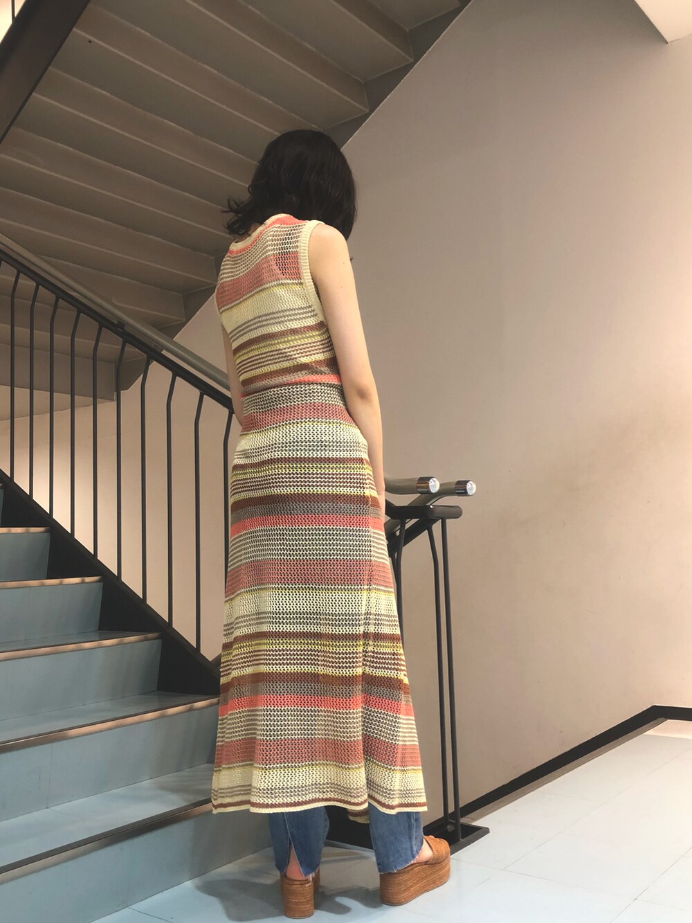 ピンク系のワンピース、ブルー系のデニムパンツ、ブラウン系のサンダルを着用したレディースの夏コーディネートの2枚目の写真