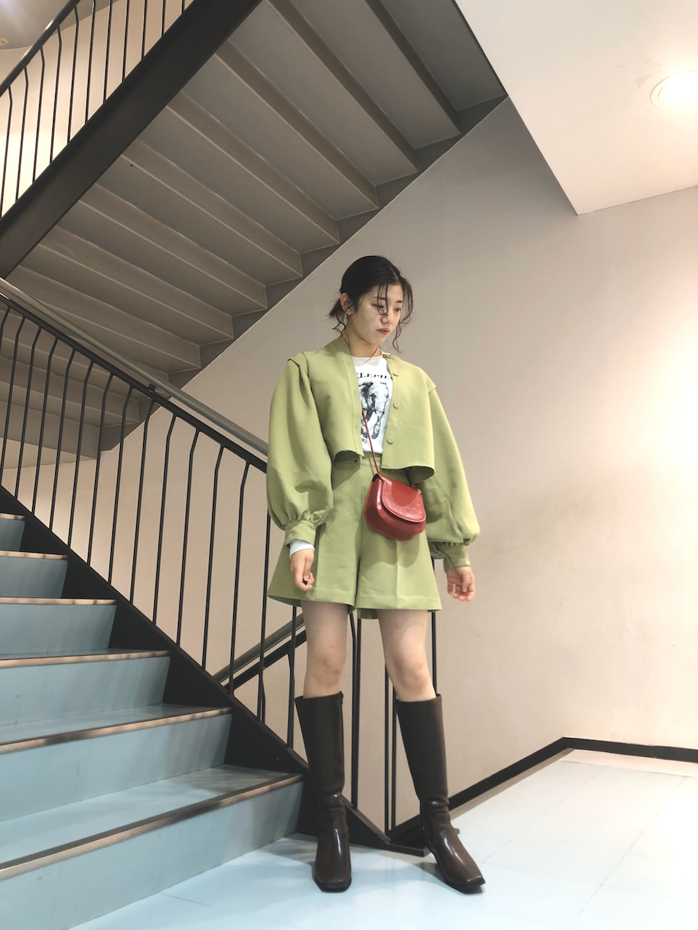 グリーン系のその他パンツ、レッド系のショルダーバッグ、ブラウン系のブーツを着用したレディースの冬コーディネートの2枚目の写真