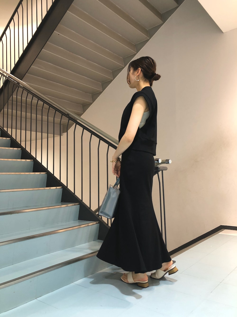 ブラック系のTシャツ/カットソー、ブラック系のスカート、ブルー系のトートバッグを着用したレディースの春コーディネートの3枚目の写真