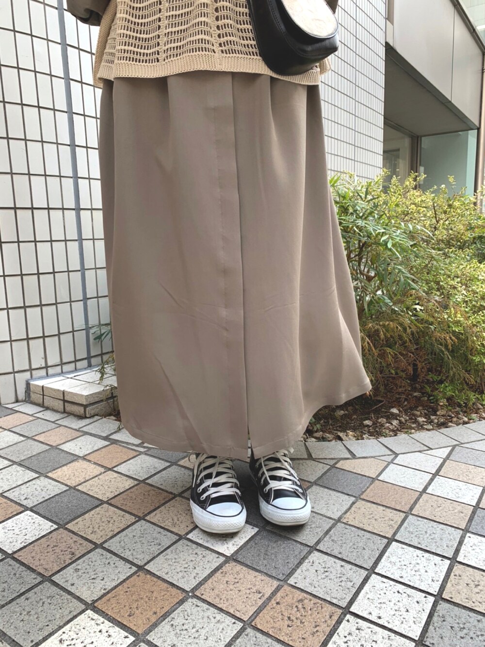 ベージュ系のニット/セーター、ブラック系のショルダーバッグ、グリーン系のワンピースを着用したレディースの春コーディネートの4枚目の写真
