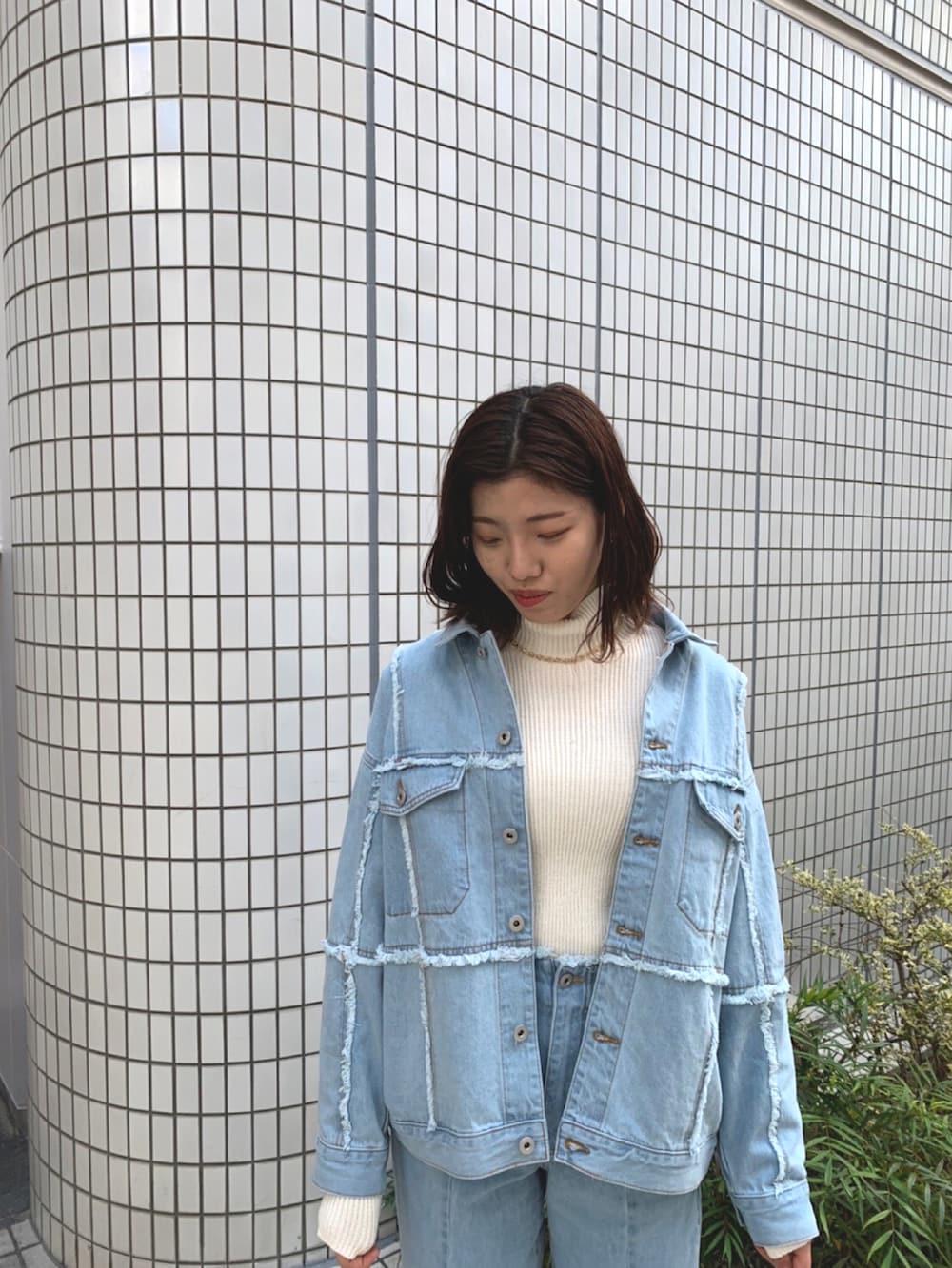 ホワイト系のニット/セーター、ブルー系のデニムジャケット、ブルー系のデニムパンツを着用したレディースの春コーディネートの3枚目の写真