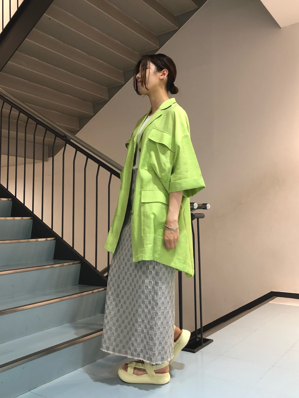 グリーン系のシャツ/ブラウス、ホワイト系のタンクトップ、グレー系のスカートを着用したレディースの春コーディネートの2枚目の写真