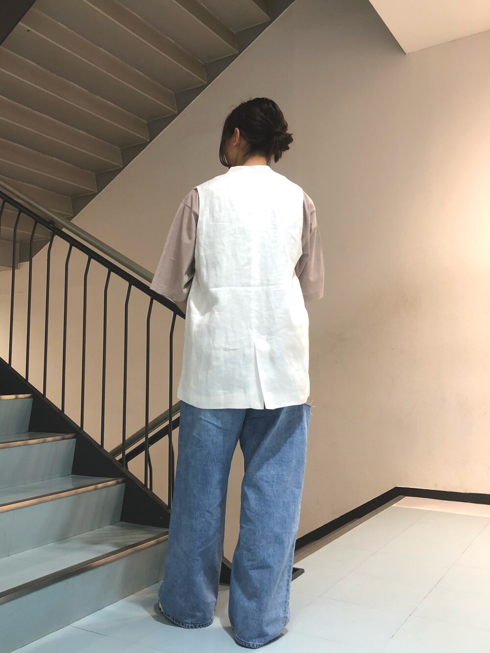 ホワイト系のベスト、ブラック系のTシャツ/カットソー、ブルー系のデニムパンツを着用したレディースの春コーディネートの2枚目の写真