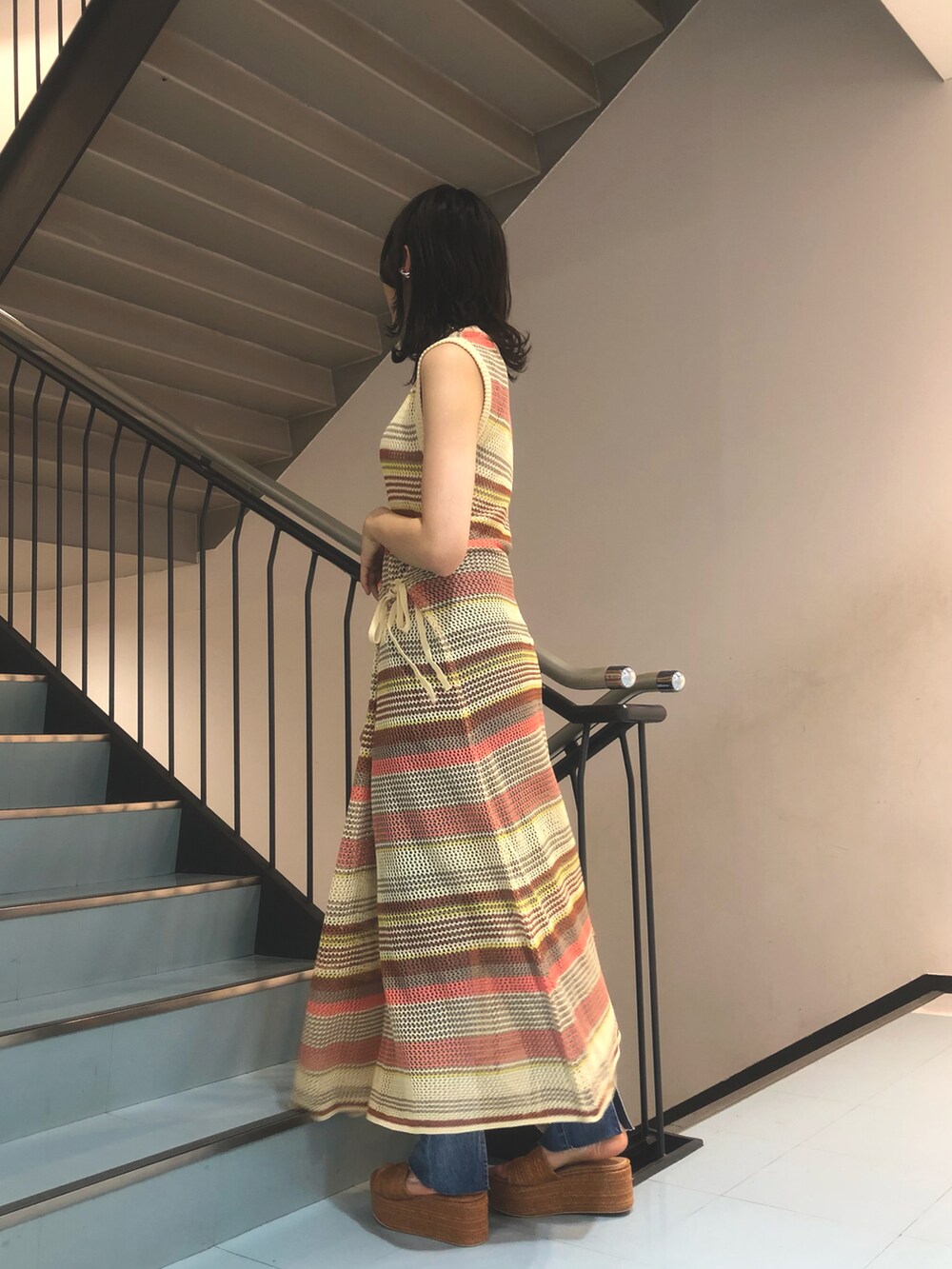 ピンク系のワンピース、ブルー系のデニムパンツ、ブラウン系のサンダルを着用したレディースの夏コーディネートの3枚目の写真