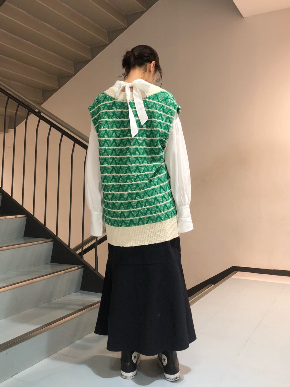 グリーン系のベスト、ホワイト系のシャツ/ブラウスを着用したレディースの冬コーディネートの2枚目の写真