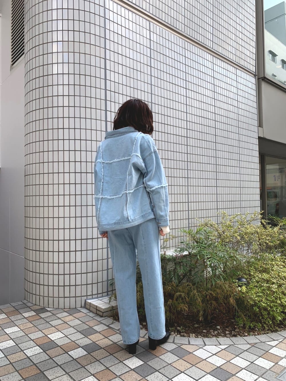 ホワイト系のニット/セーター、ブルー系のデニムジャケット、ブルー系のデニムパンツを着用したレディースの春コーディネートの2枚目の写真