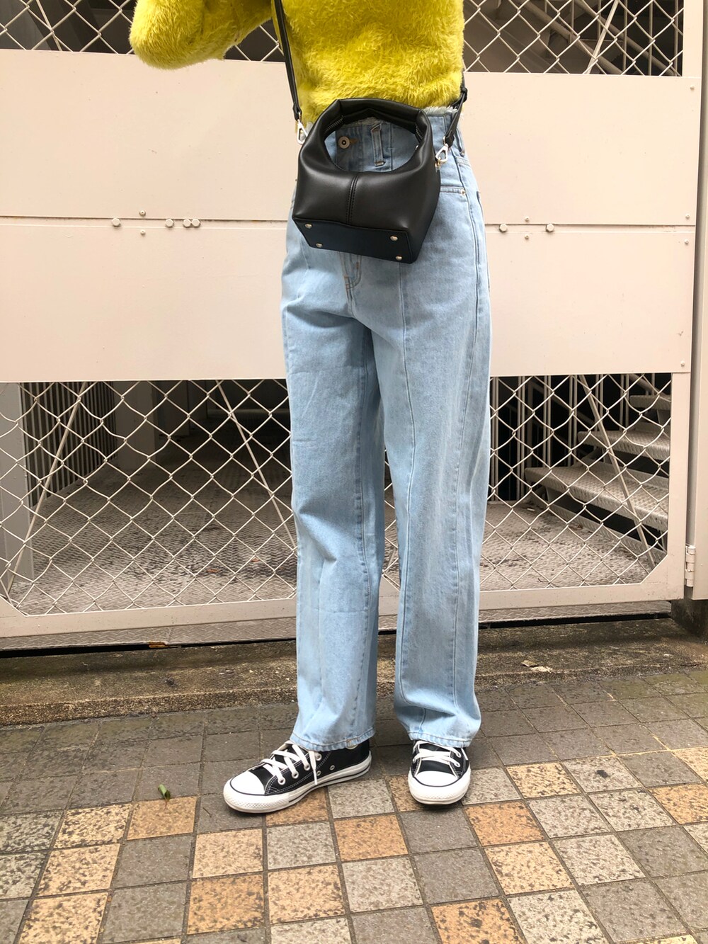 イエロー系のニット/セーター、ブルー系のデニムパンツを着用したレディースの春コーディネートの5枚目の写真