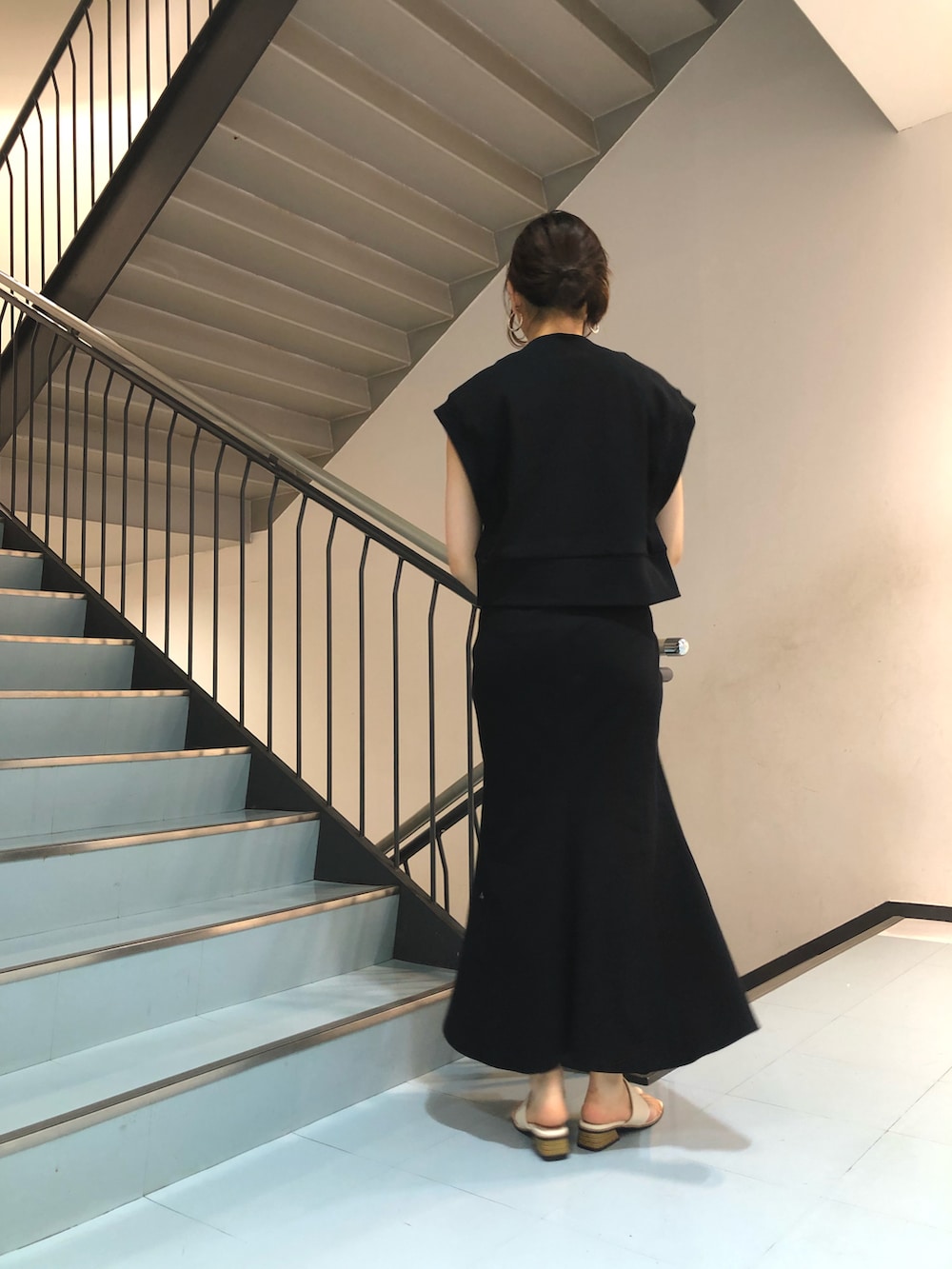 ブラック系のTシャツ/カットソー、ブラック系のスカート、ブルー系のトートバッグを着用したレディースの春コーディネートの2枚目の写真