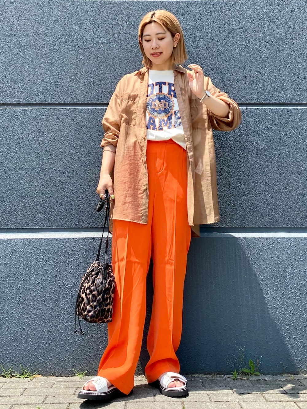 ホワイト系のTシャツ/カットソー、オレンジ系のスラックス、その他のショルダーバッグを着用したレディースの夏コーディネートの2枚目の写真