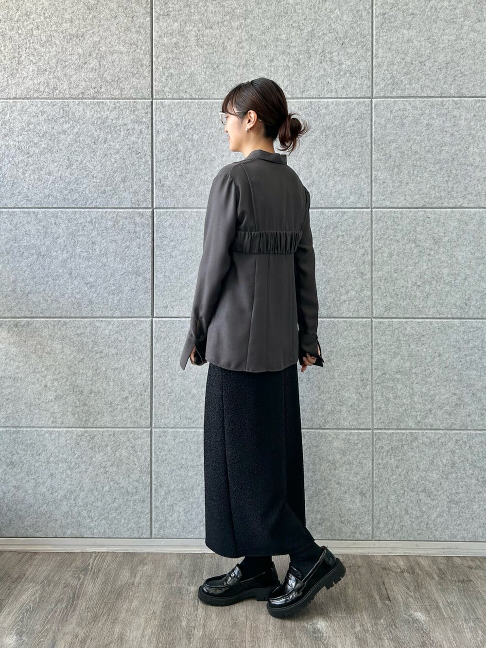 ブラック系のスカート、グレー系のシャツ/ブラウスを着用したレディースの冬コーディネートの2枚目の写真