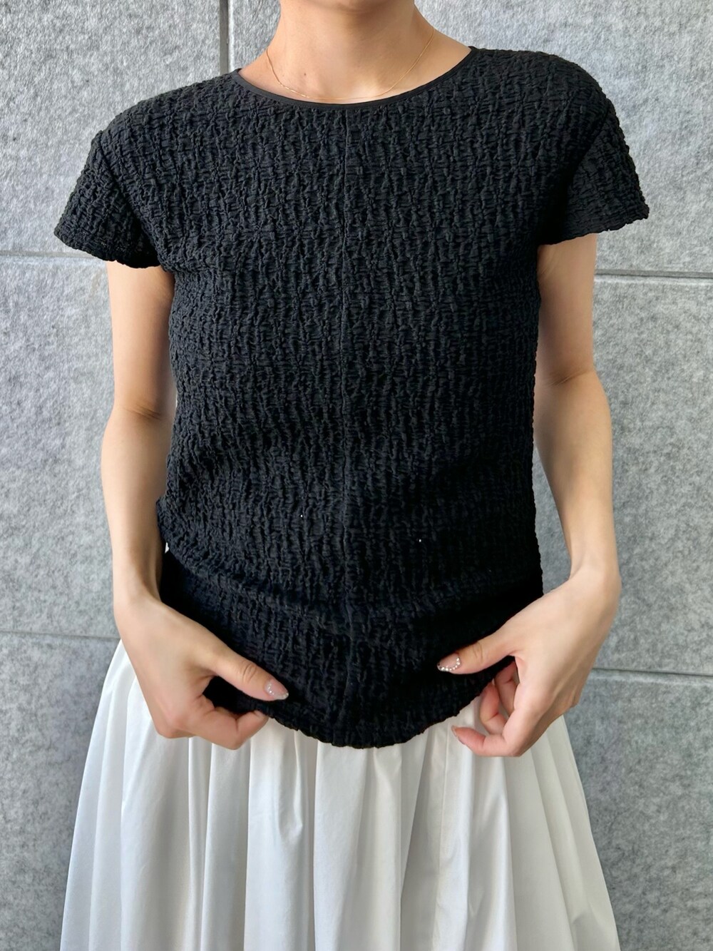 ブラック系のTシャツ/カットソー、ホワイト系のスカートを着用したレディースの夏コーディネートの4枚目の写真