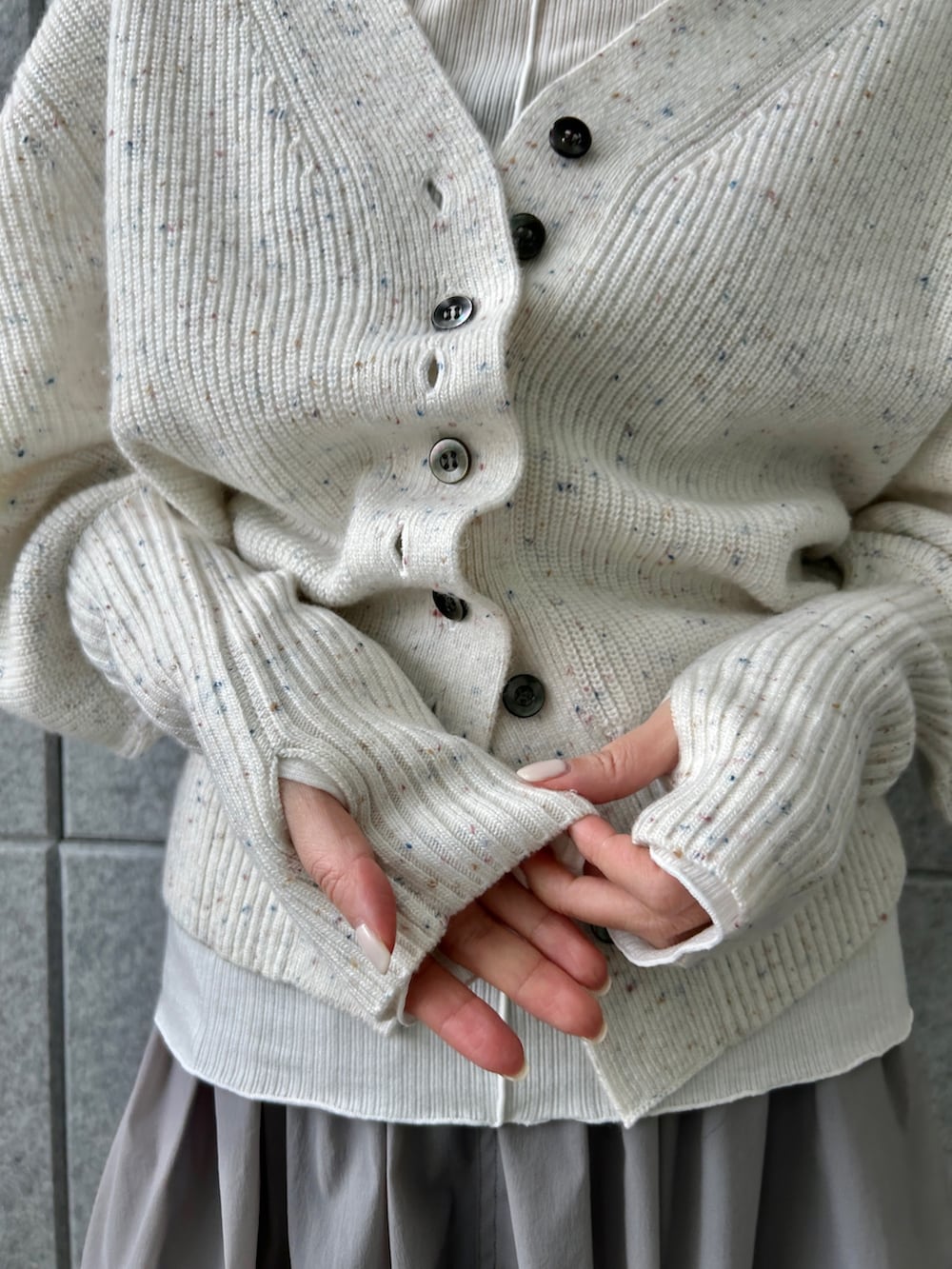 ホワイト系のカーディガン/ボレロ、グレー系のスカート、ホワイト系のTシャツ/カットソーを着用したレディースの冬コーディネートの6枚目の写真