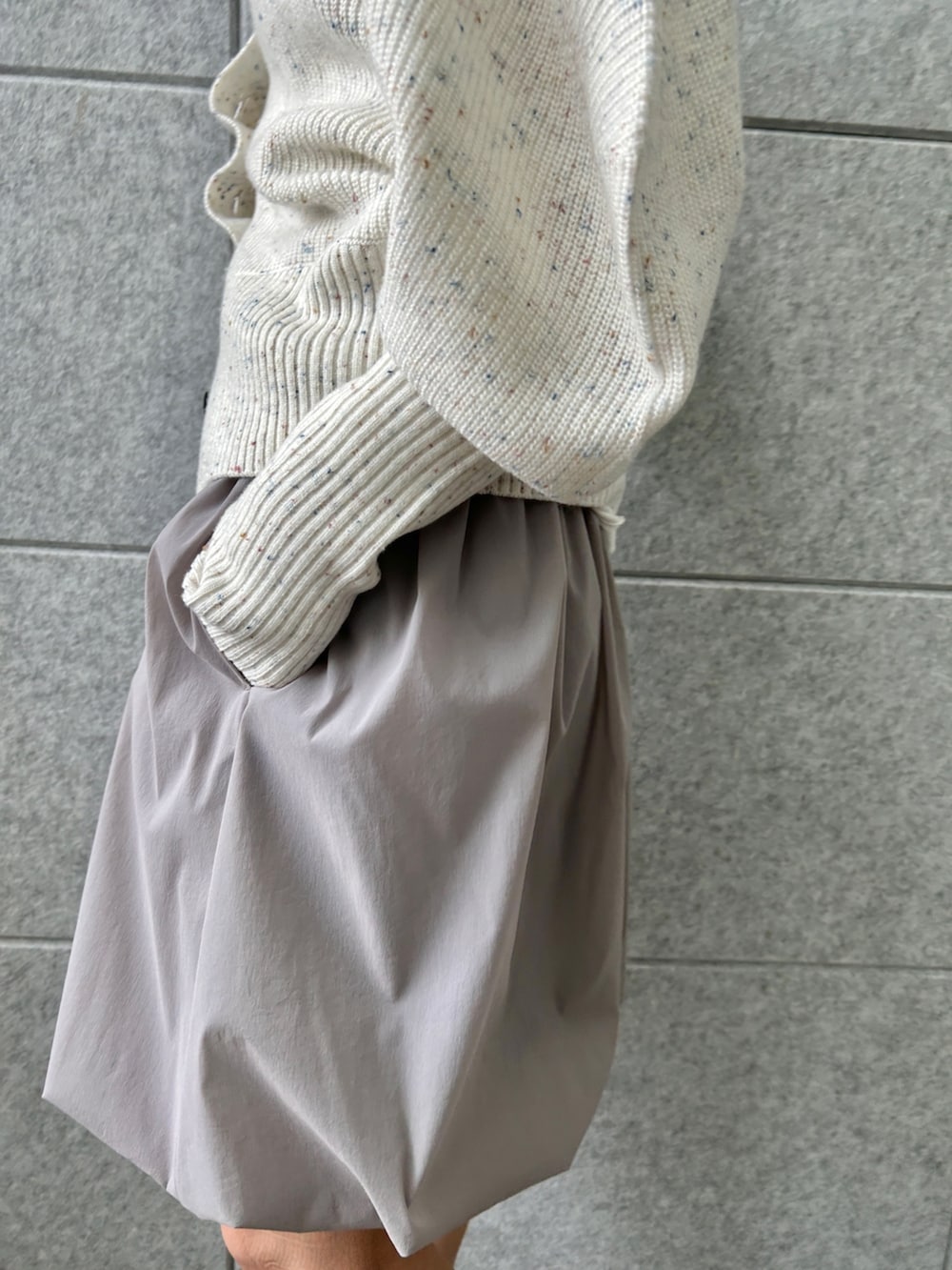 ホワイト系のカーディガン/ボレロ、グレー系のスカート、ホワイト系のTシャツ/カットソーを着用したレディースの冬コーディネートの8枚目の写真