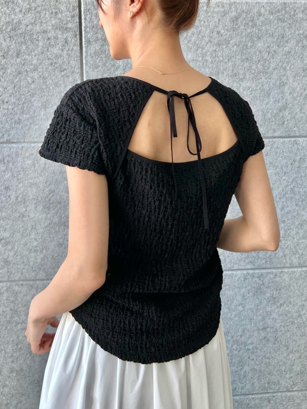 ブラック系のTシャツ/カットソー、ホワイト系のスカートを着用したレディースの夏コーディネートの5枚目の写真