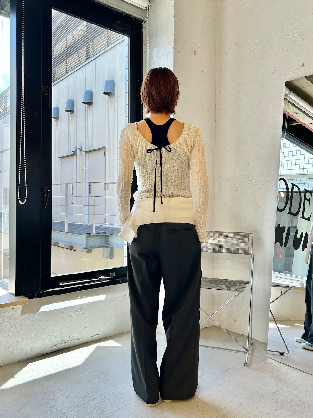 ブラック系のタンクトップ、ホワイト系のカーディガン/ボレロを着用したレディースの夏コーディネートの2枚目の写真