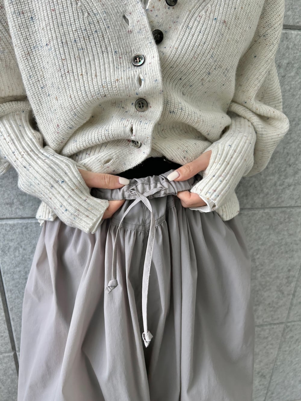 ホワイト系のカーディガン/ボレロ、グレー系のスカート、ホワイト系のTシャツ/カットソーを着用したレディースの冬コーディネートの9枚目の写真