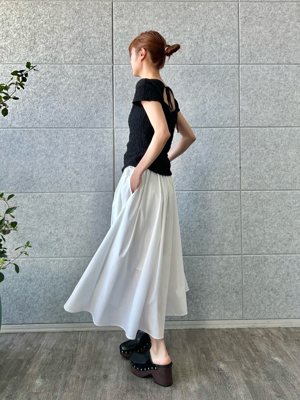 ブラック系のTシャツ/カットソー、ホワイト系のスカートを着用したレディースの夏コーディネートの2枚目の写真
