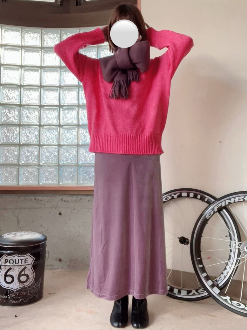 ピンク系のニット/セーター、パープル系のスカート、グレー系のジャケット/アウターを着用したレディースの冬コーディネートの3枚目の写真