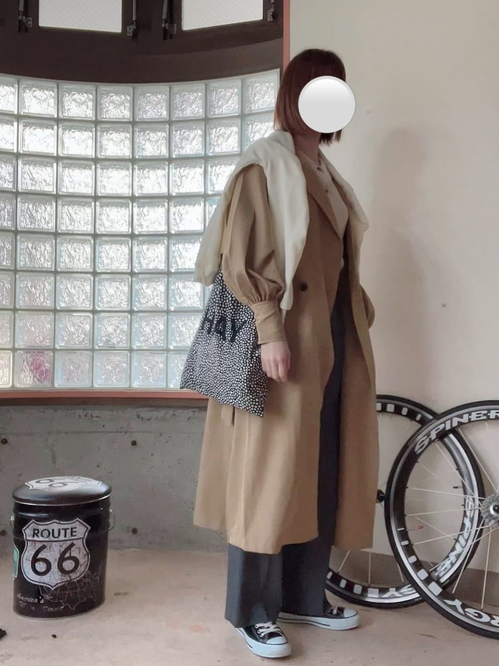 ホワイト系のスウェット、ベージュ系のニット/セーター、ベージュ系のトレンチコートを着用したレディースの春コーディネートの3枚目の写真