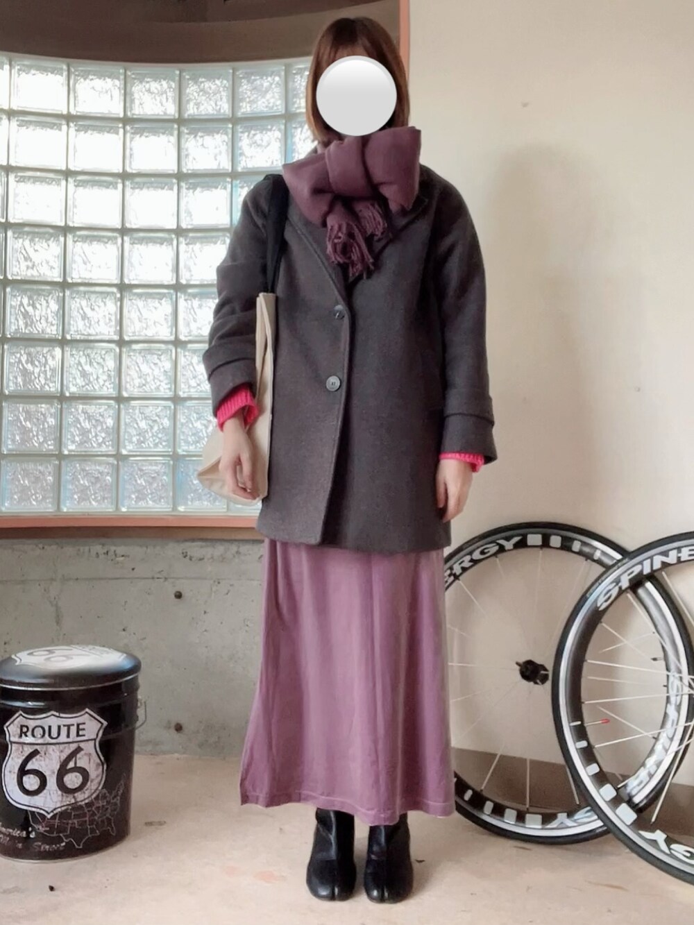 ピンク系のニット/セーター、パープル系のスカート、グレー系のジャケット/アウターを着用したレディースの冬コーディネートの2枚目の写真