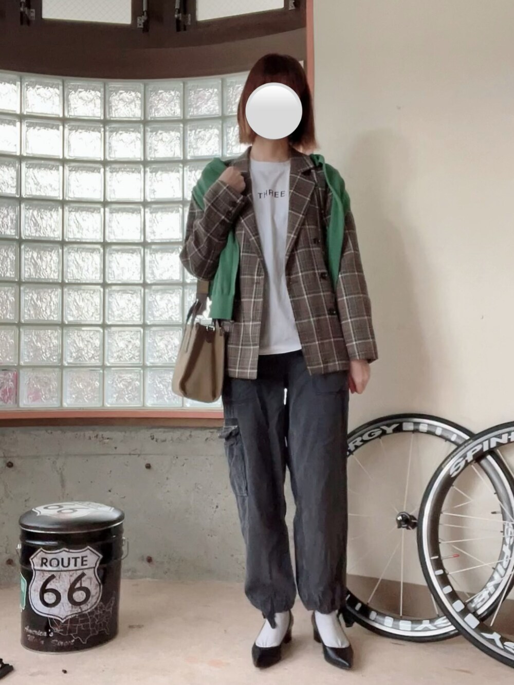 ホワイト系のTシャツ/カットソー、ブラウン系のテーラードジャケット、グリーン系のカーディガン/ボレロを着用したレディースの春コーディネートの2枚目の写真