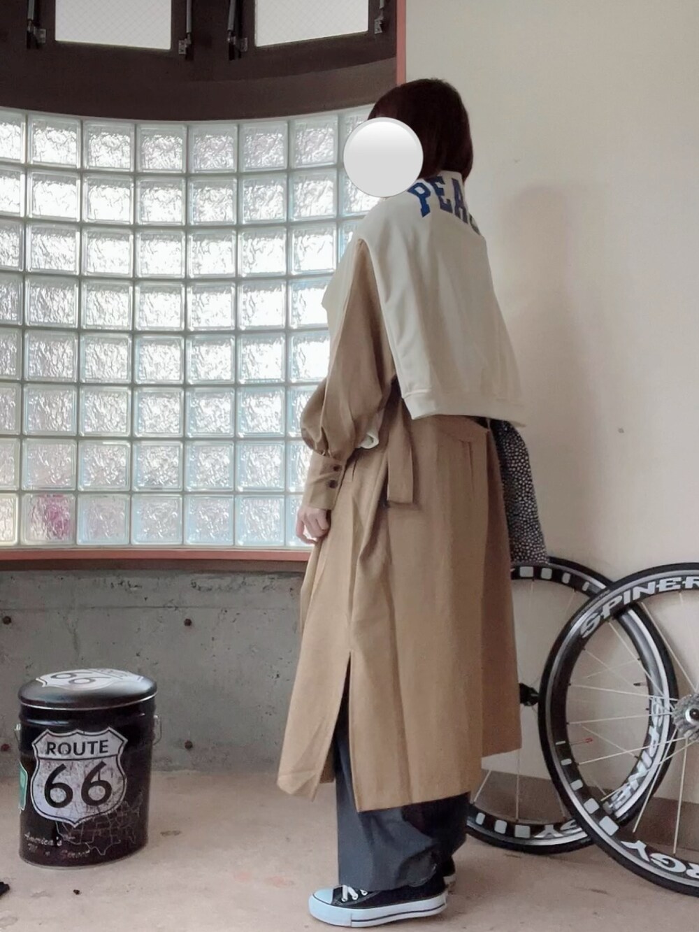 ホワイト系のスウェット、ベージュ系のニット/セーター、ベージュ系のトレンチコートを着用したレディースの春コーディネートの2枚目の写真