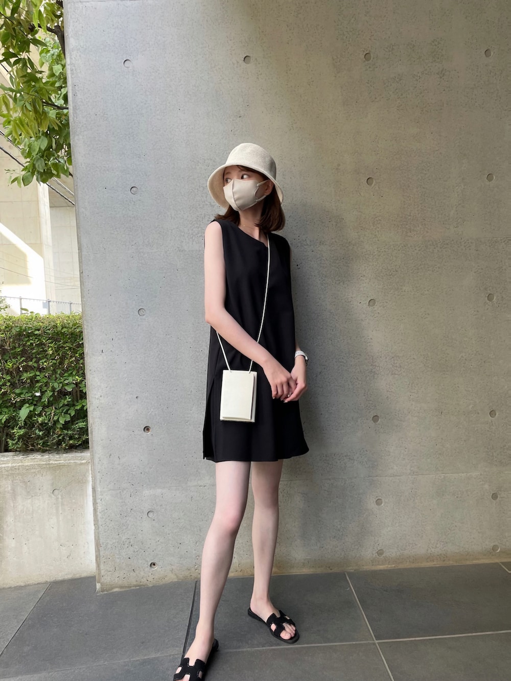 ブラック系のサンダル、ホワイト系のショルダーバッグ、ブラック系のワンピースを着用したレディースの夏コーディネートの4枚目の写真
