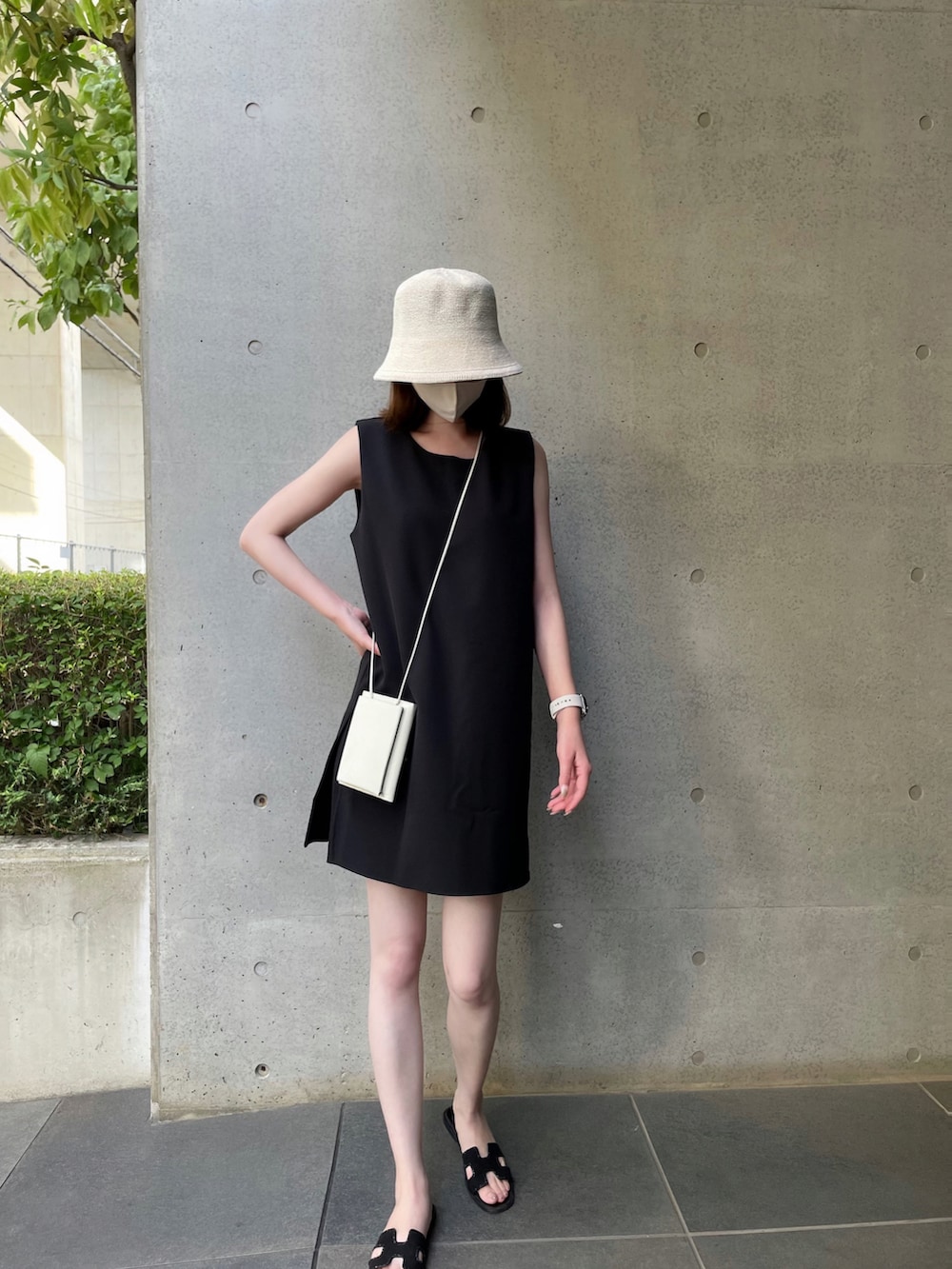 ブラック系のサンダル、ホワイト系のショルダーバッグ、ブラック系のワンピースを着用したレディースの夏コーディネートの5枚目の写真