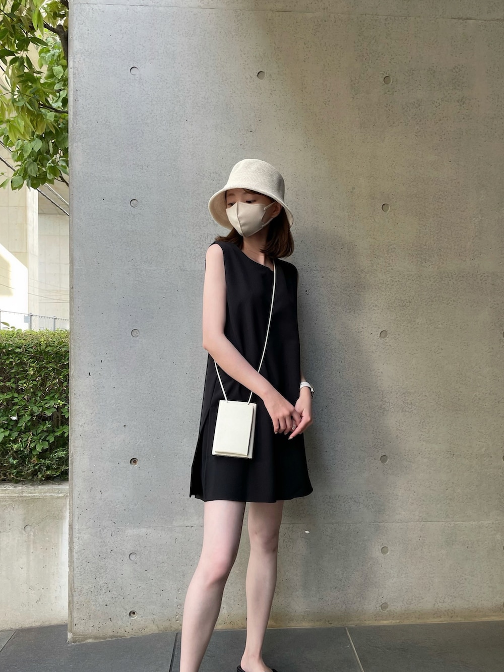 ブラック系のサンダル、ホワイト系のショルダーバッグ、ブラック系のワンピースを着用したレディースの夏コーディネートの2枚目の写真