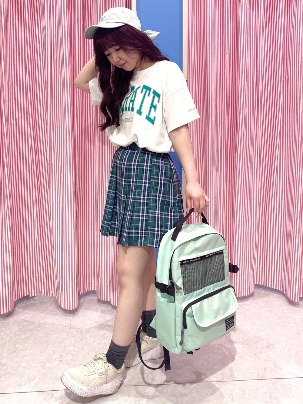 グリーン系のバックパック/リュック、グリーン系のスカート、ホワイト系のワンピースを着用したレディースの夏コーディネートの2枚目の写真