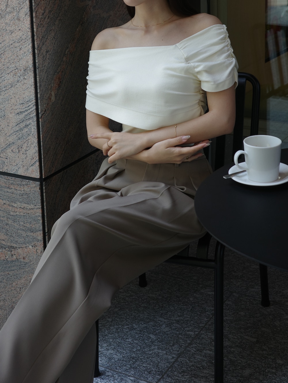 ホワイト系のニット/セーター、ベージュ系のスラックスを着用したレディースの春コーディネートの4枚目の写真