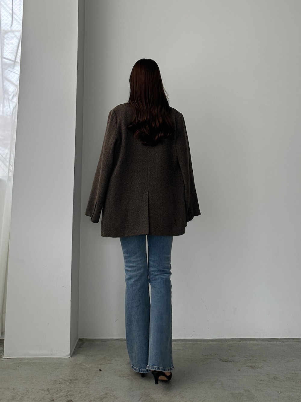 ブルー系のデニムパンツ、ブラウン系のテーラードジャケットを着用したレディースの秋コーディネートの2枚目の写真