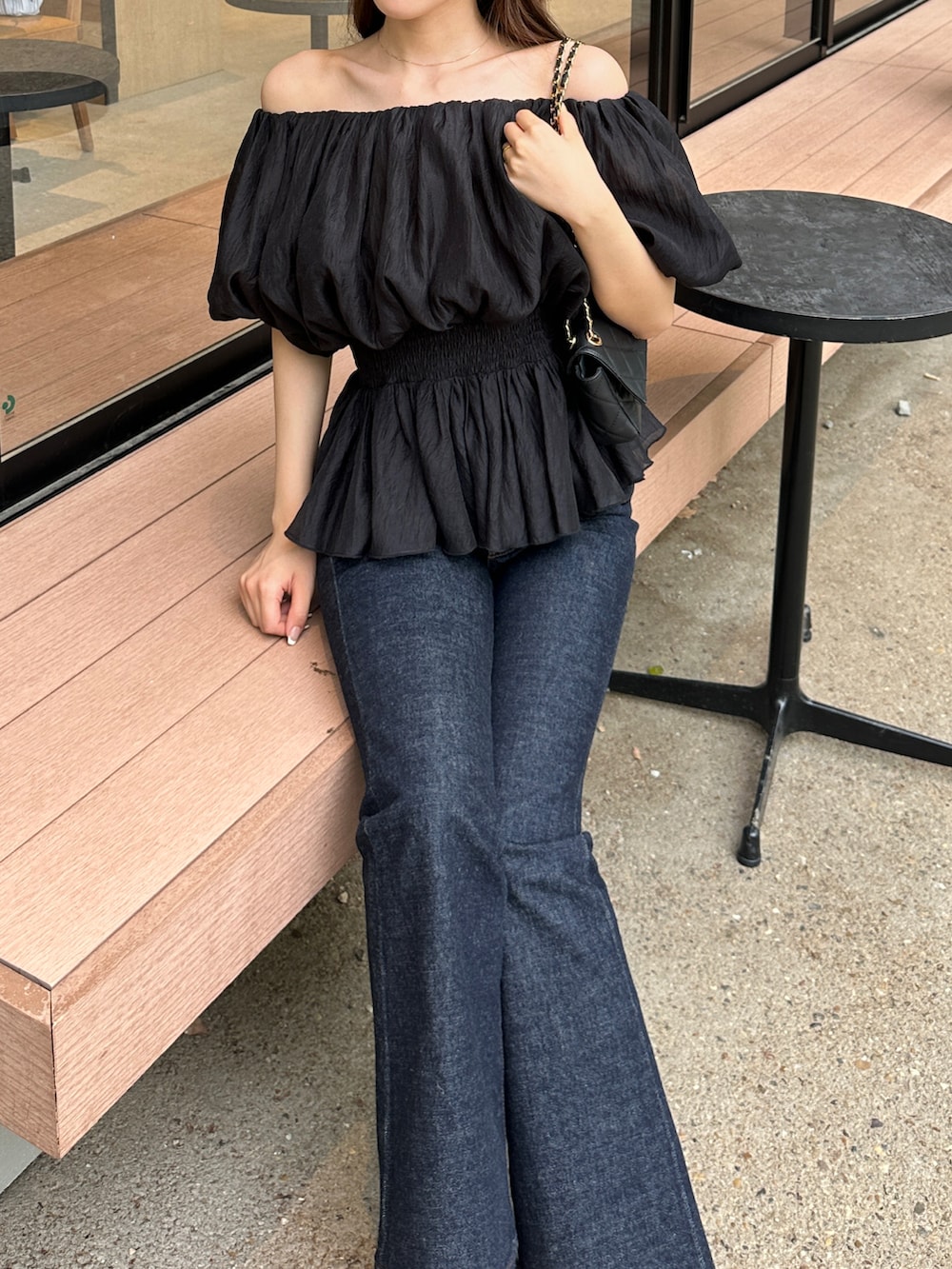 ブルー系のデニムパンツ、ブラック系のシャツ/ブラウスを着用したレディースの春コーディネートの3枚目の写真