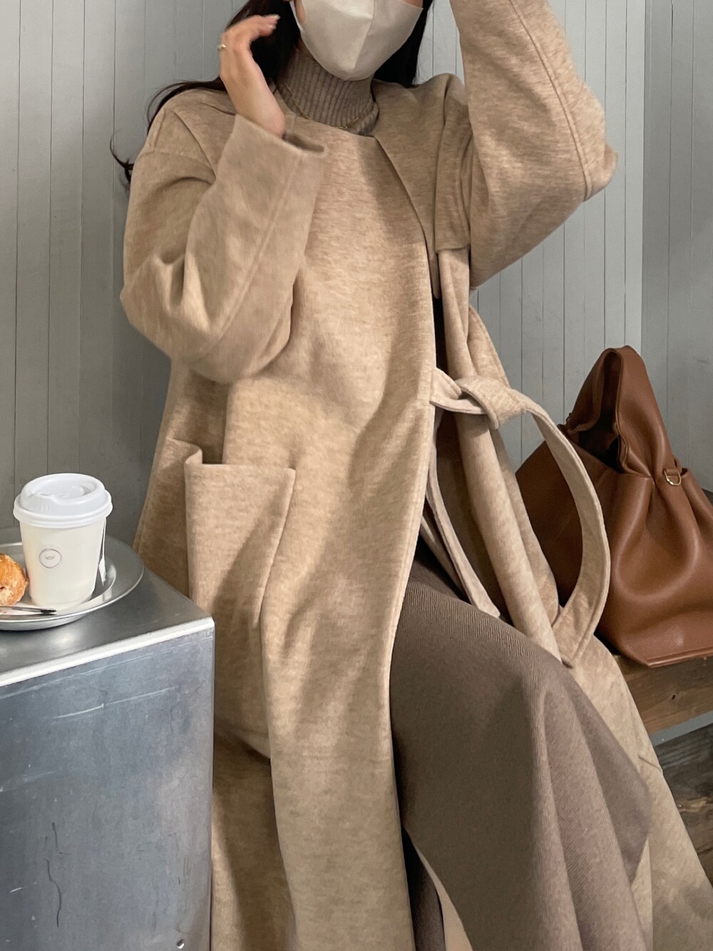 ブラウン系のバッグ、ベージュ系のシューズ、ベージュ系のその他アウターを着用したレディースの冬コーディネートの3枚目の写真