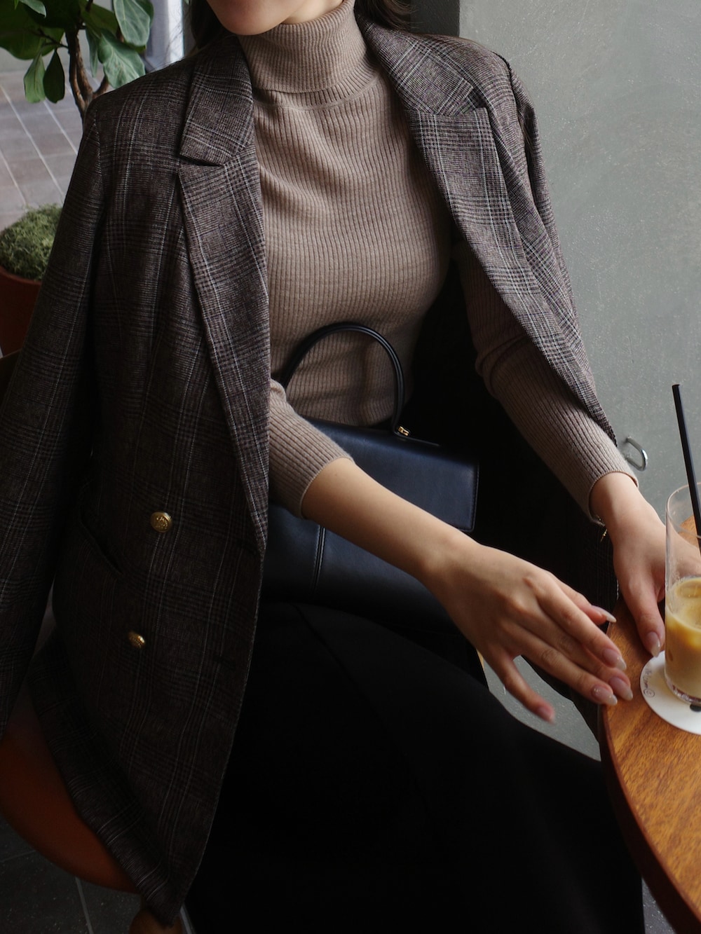 ブラック系のスカート、ブラウン系のテーラードジャケットを着用したレディースの秋コーディネートの4枚目の写真