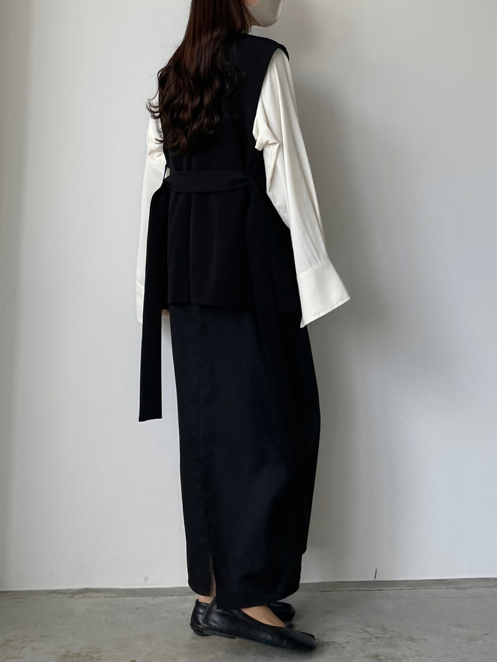 ベージュ系のシャツ/ブラウス、ブラック系のベスト、ブラック系のスカートを着用したレディースの秋コーディネートの3枚目の写真