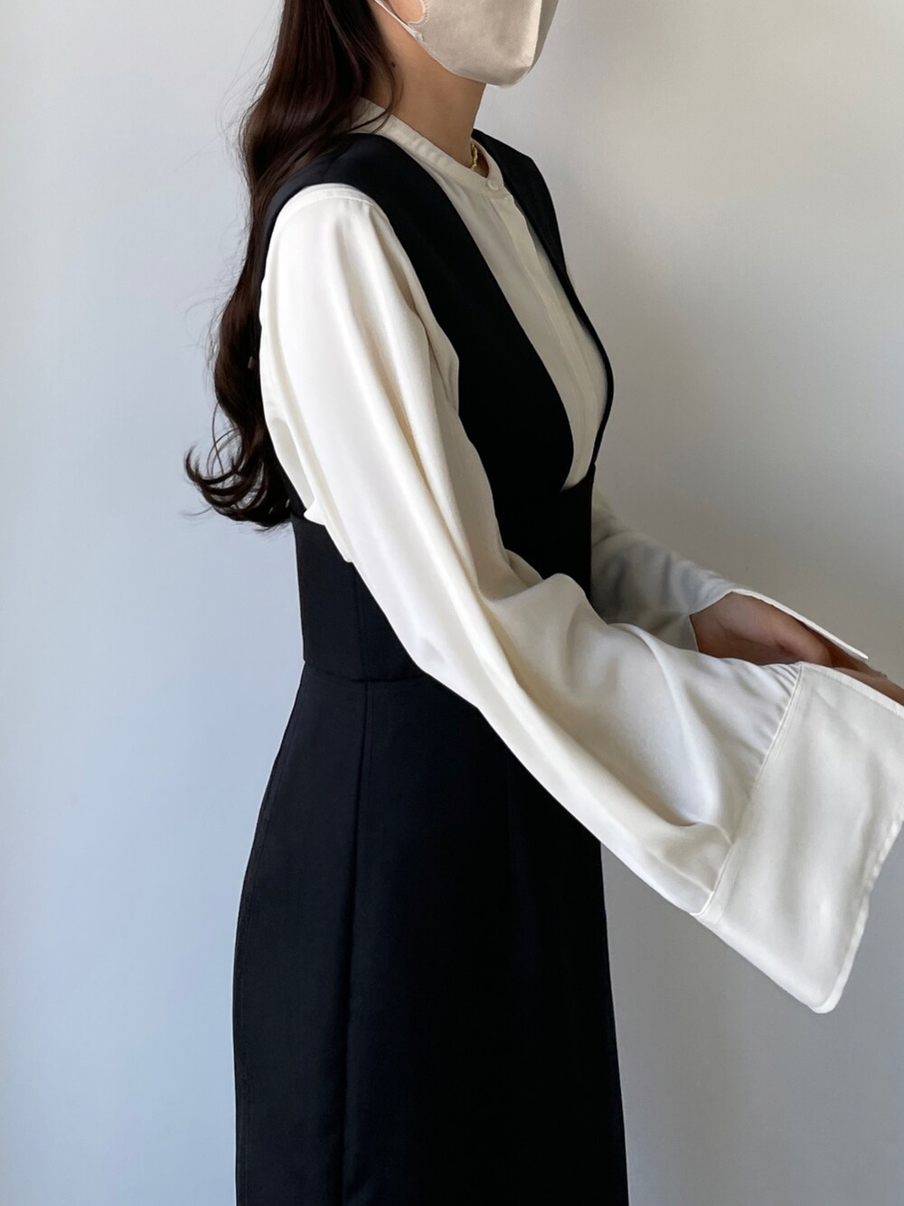 ベージュ系のシャツ/ブラウス、ブラック系のベスト、ブラック系のスカートを着用したレディースの秋コーディネートの2枚目の写真