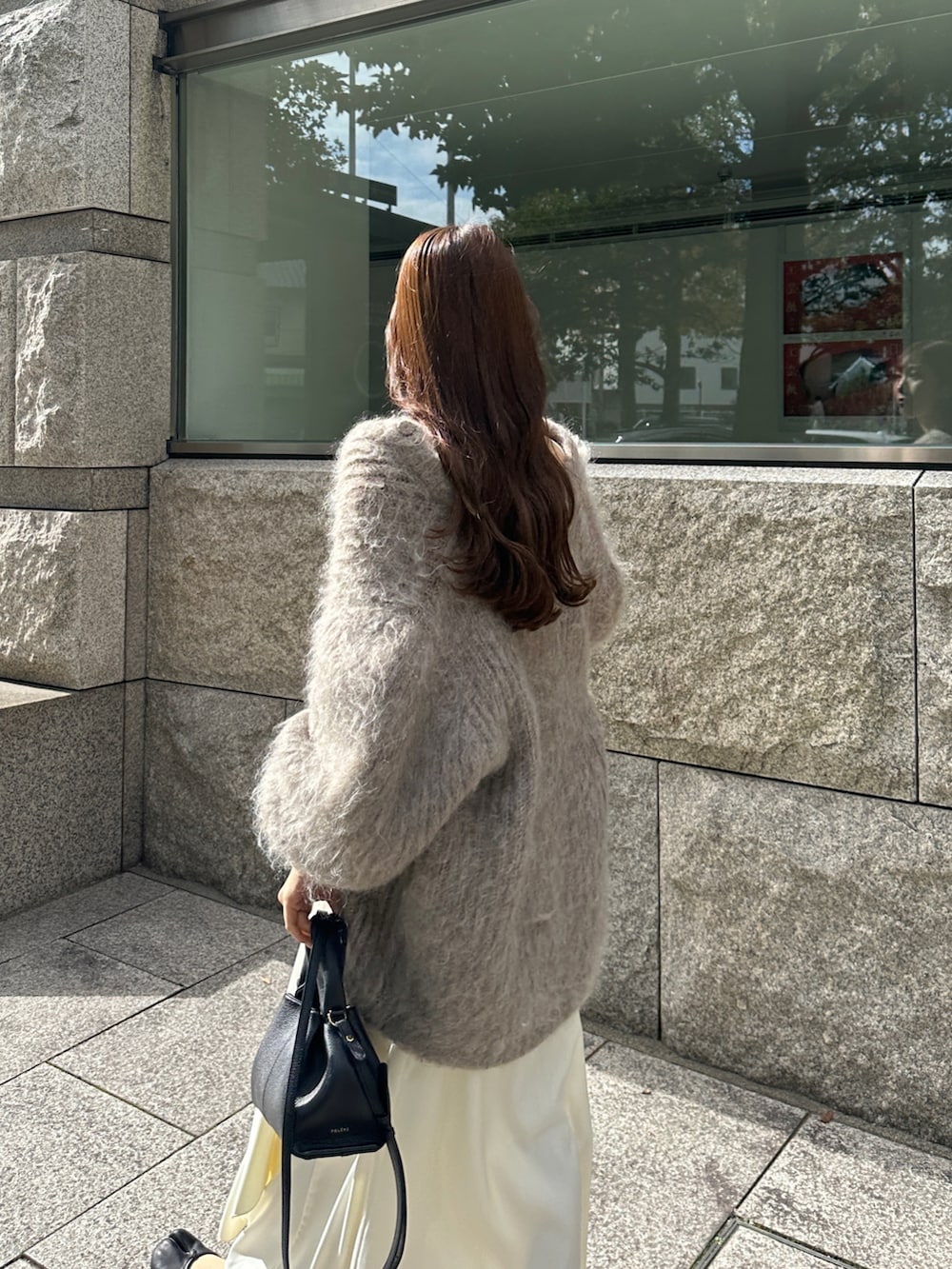 ホワイト系のワンピース、ベージュ系のカーディガン/ボレロを着用したレディースの秋コーディネートの3枚目の写真