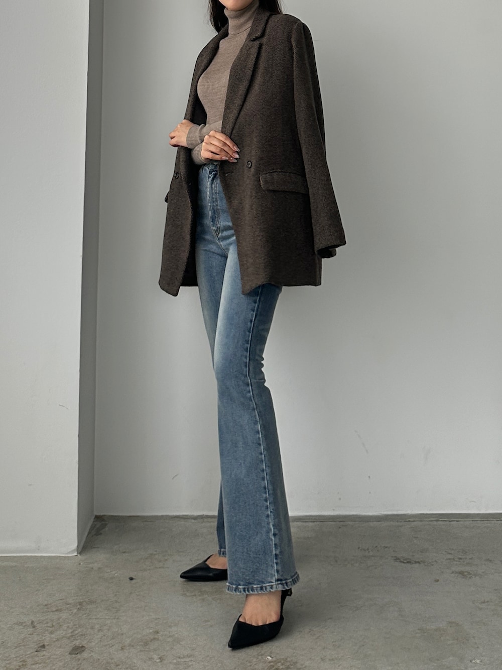 ブルー系のデニムパンツ、ブラウン系のテーラードジャケットを着用したレディースの秋コーディネートの3枚目の写真