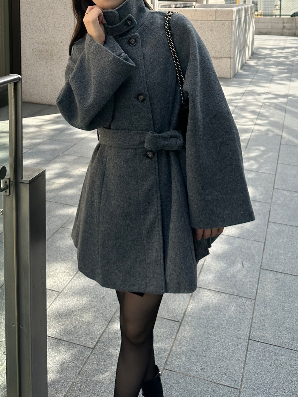 グレー系のステンカラーコートを着用したレディースの秋コーディネートの5枚目の写真