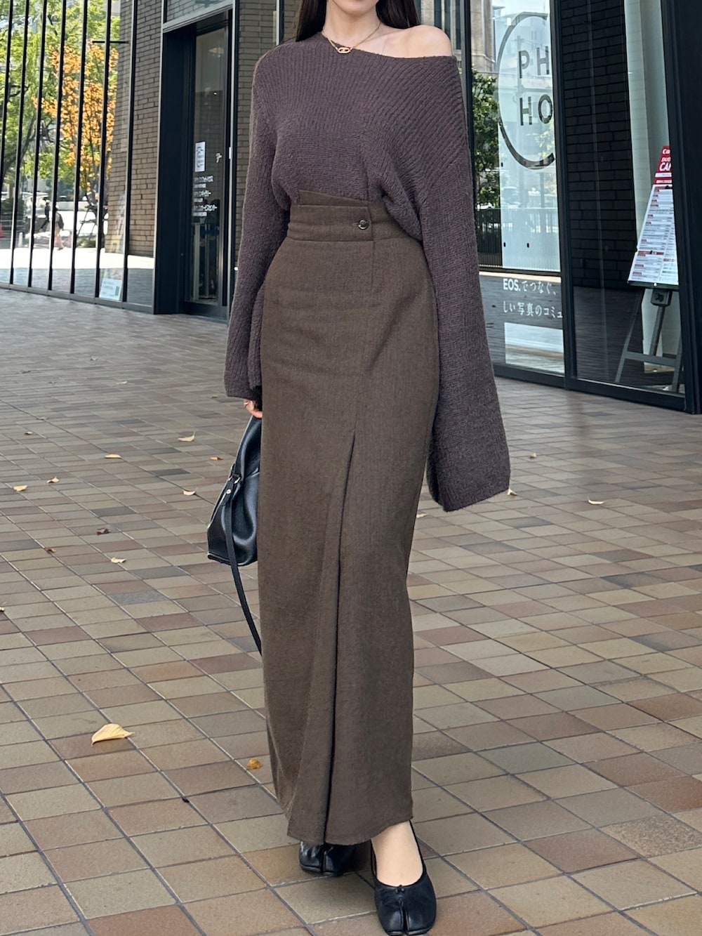 ブラウン系のニット/セーター、ブラウン系のスカートを着用したレディースの秋コーディネートの2枚目の写真