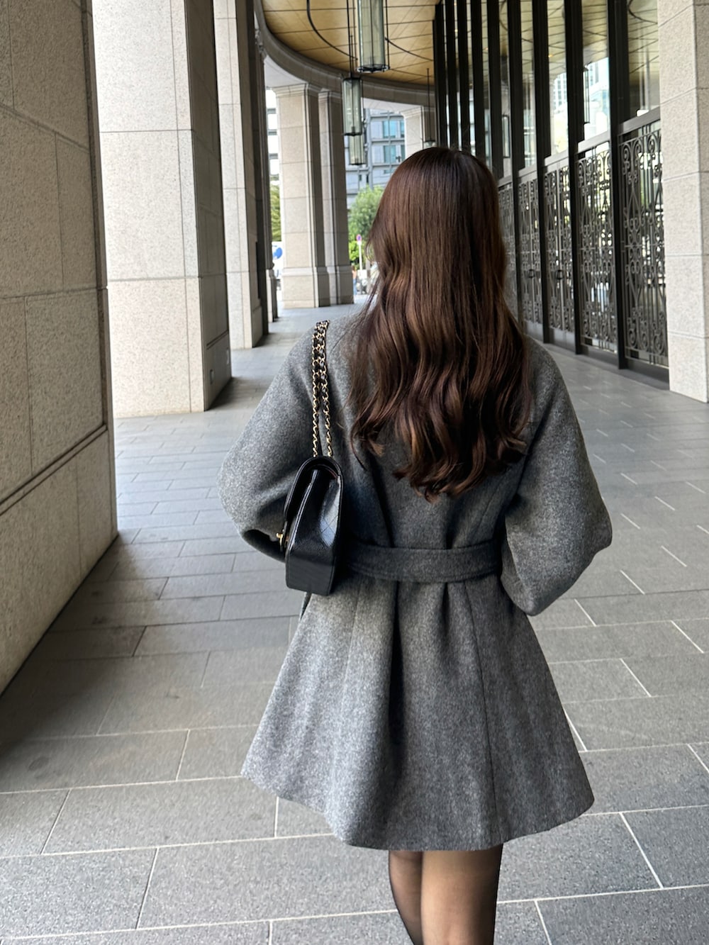 グレー系のステンカラーコートを着用したレディースの秋コーディネートの4枚目の写真