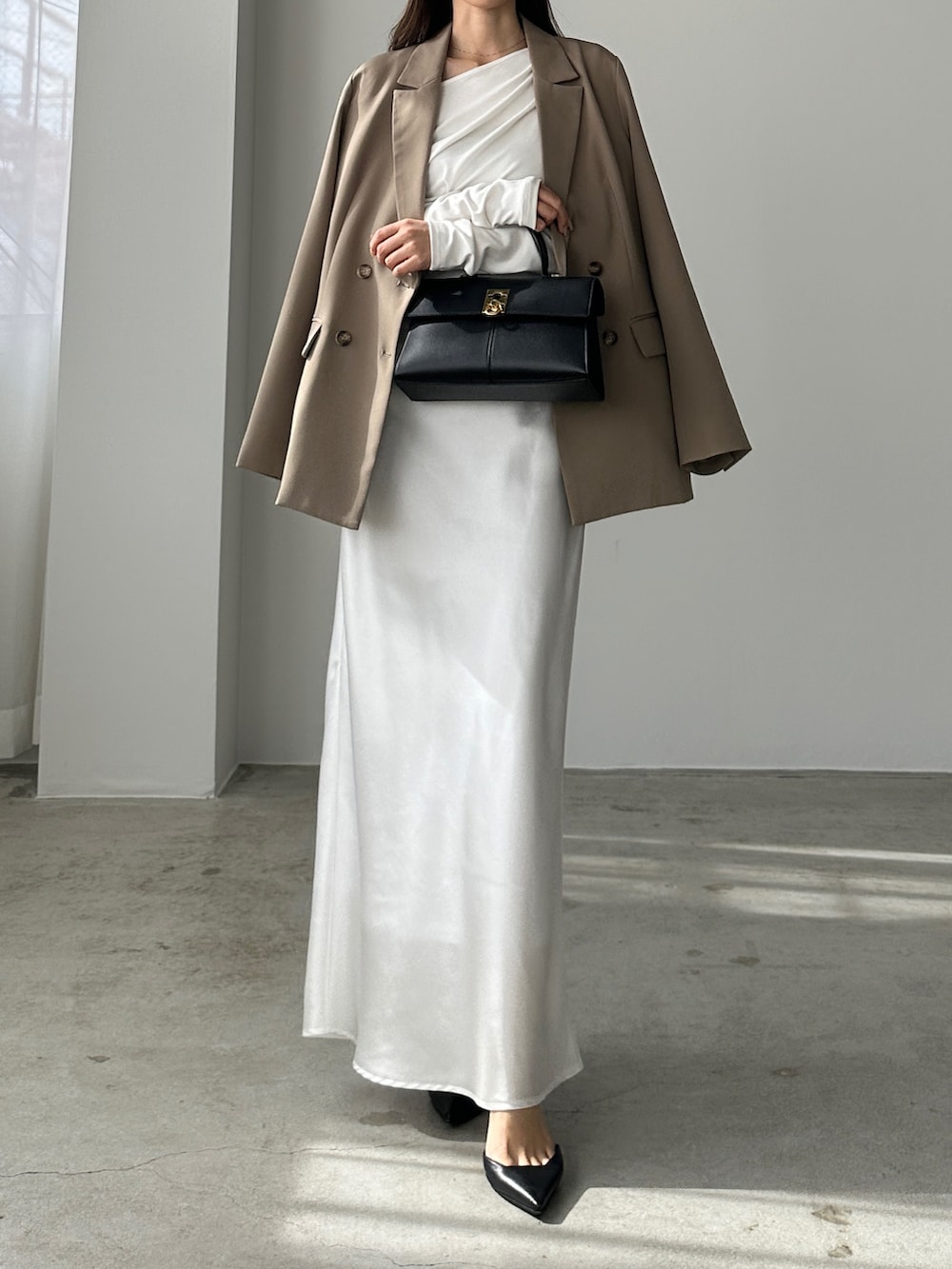 ベージュ系のテーラードジャケット、ブラック系のハンドバッグを着用したレディースの冬コーディネートの2枚目の写真