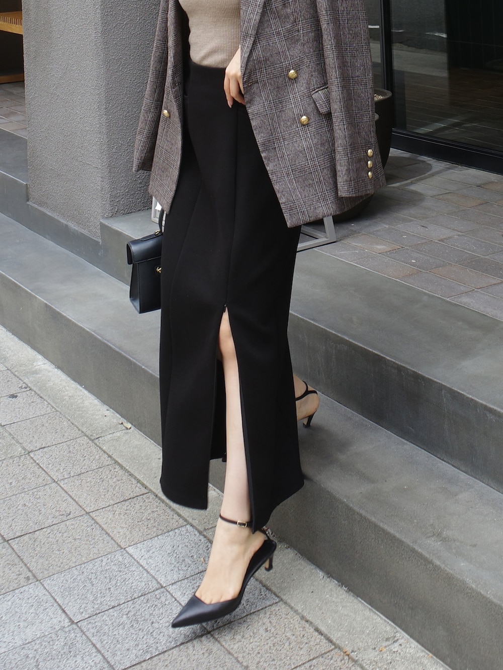 ブラック系のスカート、ブラウン系のテーラードジャケットを着用したレディースの秋コーディネートの2枚目の写真