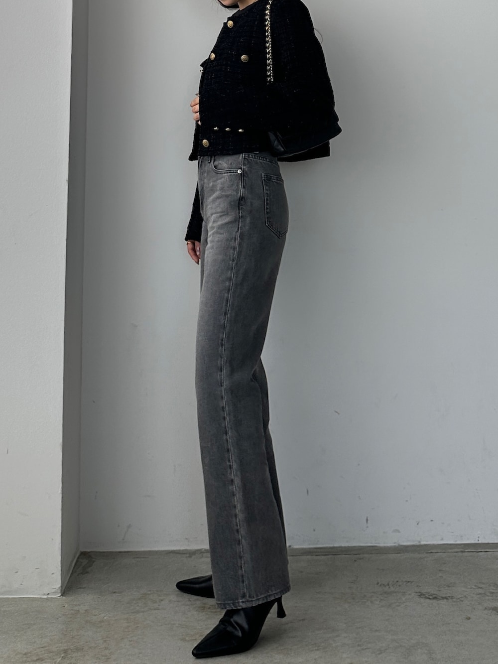 グレー系のデニムパンツ、ブラック系のノーカラージャケットを着用したレディースの秋コーディネートの2枚目の写真