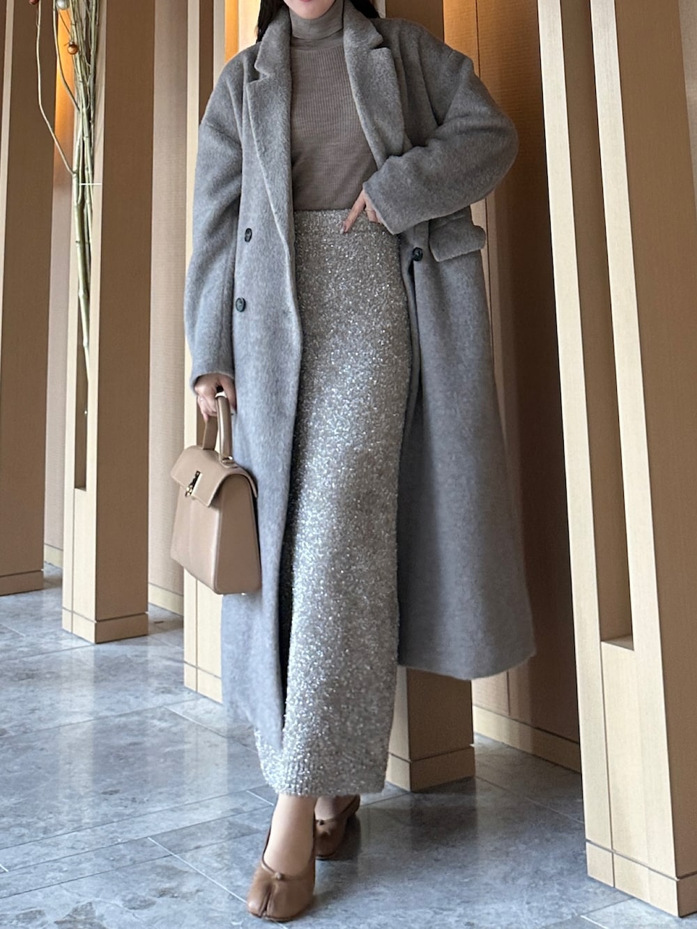 ブラウン系のチェスターコート、ベージュ系のスカートを着用したレディースの冬コーディネートの4枚目の写真