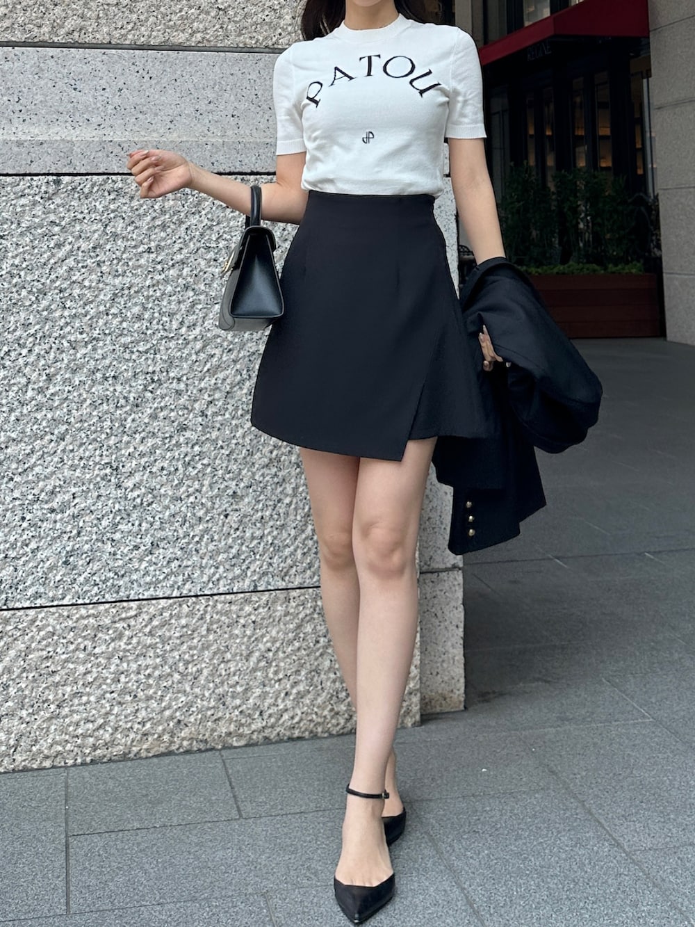 ブラック系のハンドバッグ、ブラック系のスカート、ブラック系のテーラードジャケットを着用したレディースの春コーディネートの5枚目の写真